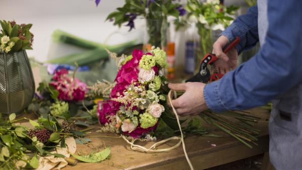 foto/close-up-male-florist-creating-flower-bouquet-flower-shop